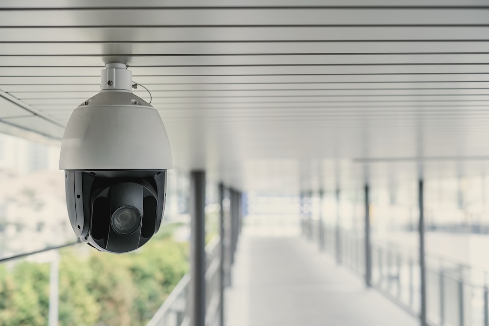 Image of a security camera hanging from a ceiling.